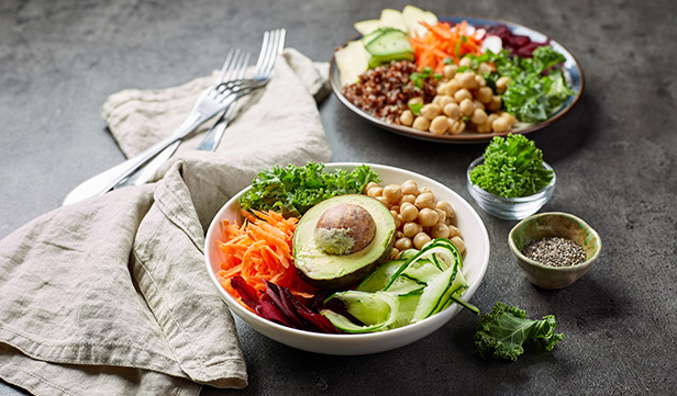 Plate and bowl filled with fresh vegetables and foods that lower blood pressure