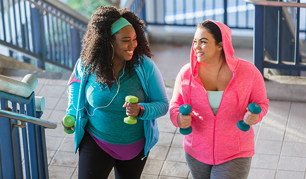 Women in bright activewear hold dumbbells and climb stairs for exercise