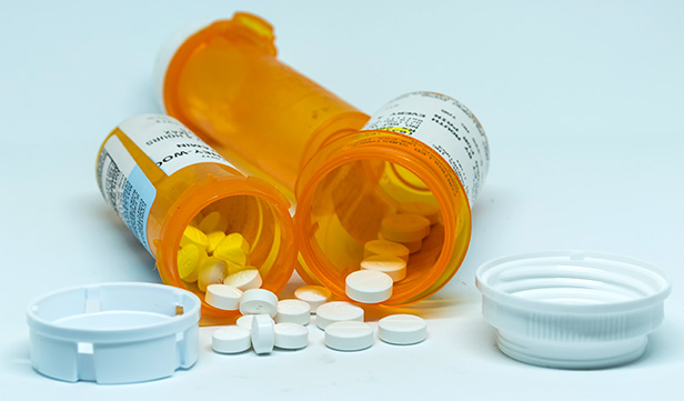 Closeup of prescription opioids spilling from amber pill bottles