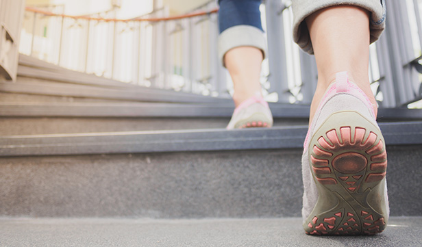 Closeup of woman’s sneakers as she climbs stairs for exercise