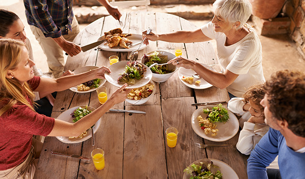 Group gathers around wooden picnic table to share heart-healthy meal