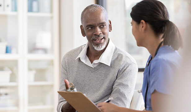 Man and health care provider discuss prostate cancer screening in medical clinic