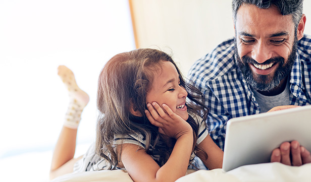 Bearded dad and young daughter spend time together on digital tablet