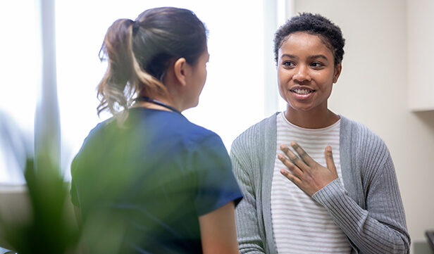 Woman in grey cardigan discusses cervical cancer screening with health care provider