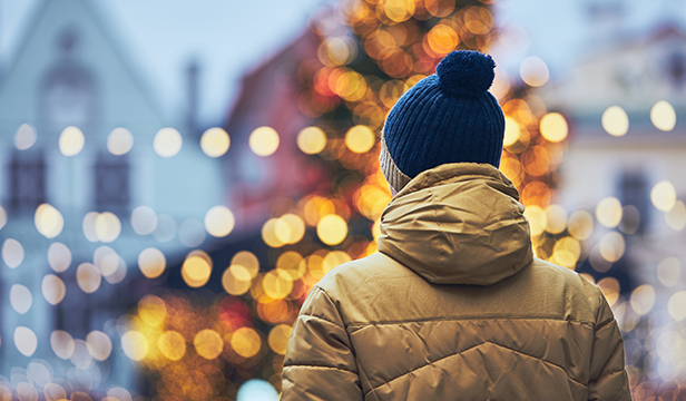 Rear view of man in warm clothing viewing holiday lights