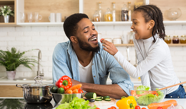 Young daughter and dad prepare healthy meal on a tight budget at home