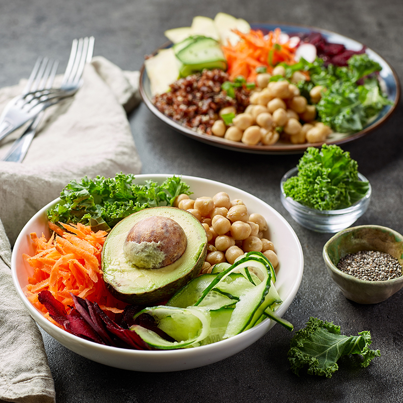 Plate and bowl filled with fresh vegetables and foods that lower blood pressure